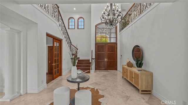 entrance foyer featuring an inviting chandelier and a towering ceiling