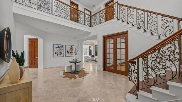 foyer entrance with a towering ceiling and french doors