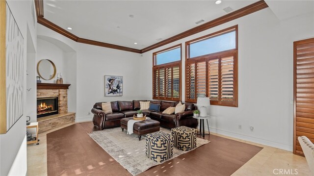 living room with ornamental molding and a fireplace