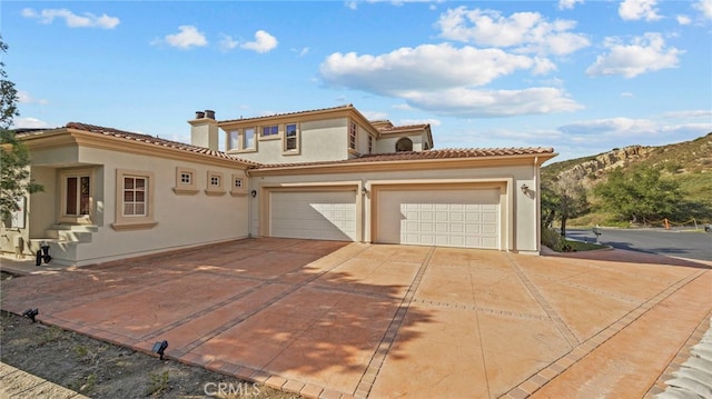 mediterranean / spanish-style house with a mountain view and a garage