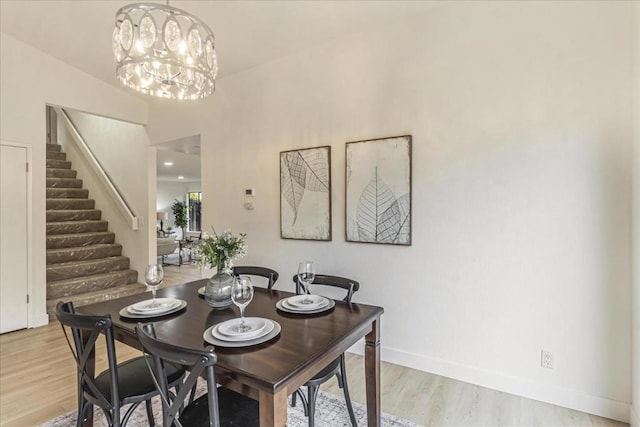 dining area featuring light wood-type flooring and a notable chandelier