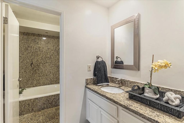 bathroom with vanity and tiled bath