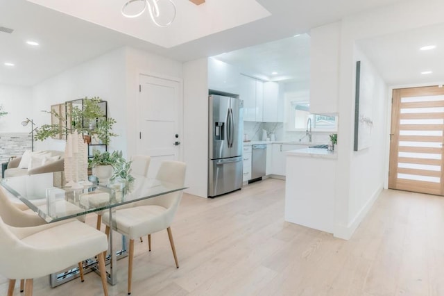 dining area featuring sink and light hardwood / wood-style floors