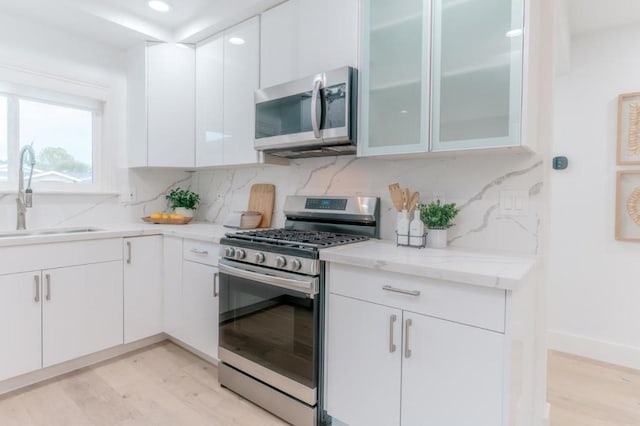 kitchen featuring white cabinetry, sink, decorative backsplash, and appliances with stainless steel finishes