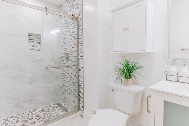 bathroom featuring an enclosed shower, vanity, and toilet