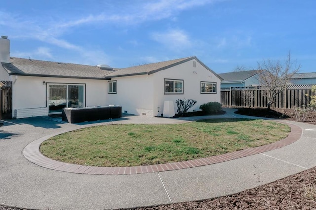 back of property with a yard and a patio area