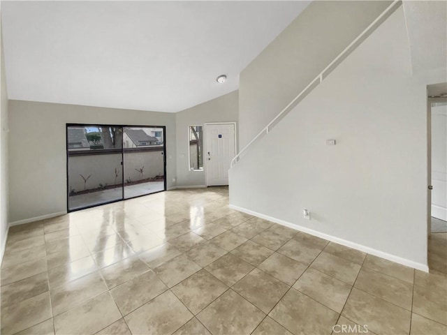 tiled spare room featuring lofted ceiling and a wealth of natural light