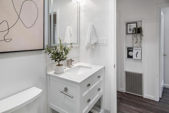 bathroom featuring vanity, hardwood / wood-style floors, and toilet