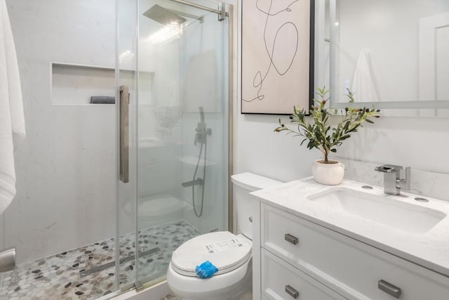 bathroom featuring vanity, toilet, and an enclosed shower