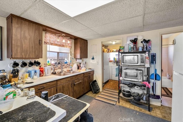 kitchen with stainless steel microwave, sink, and a paneled ceiling