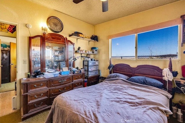 carpeted bedroom featuring ceiling fan and a textured ceiling