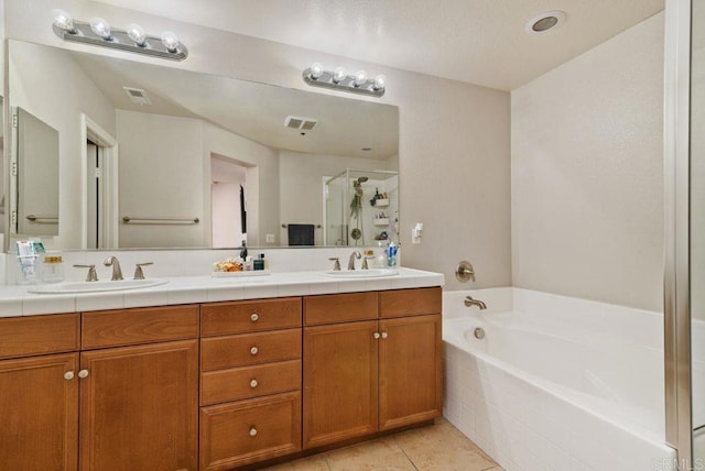 full bathroom featuring visible vents, a sink, a garden tub, and tile patterned floors