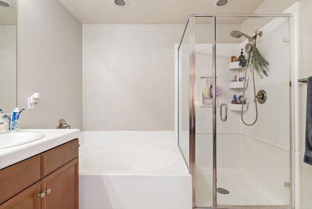 bathroom with a garden tub, a shower stall, and vanity