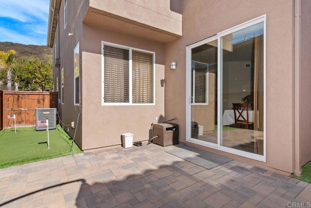 view of patio with central AC unit and fence