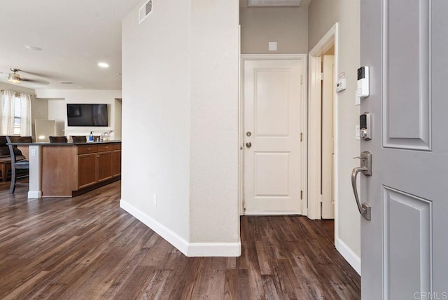 foyer featuring dark wood-type flooring, visible vents, and baseboards