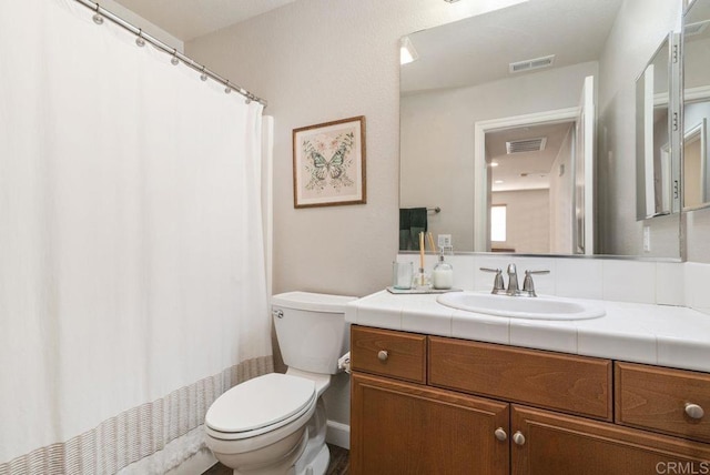 full bathroom featuring toilet, vanity, and visible vents