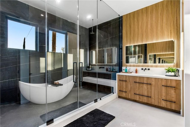 bathroom featuring vanity, tile patterned flooring, tile walls, and separate shower and tub