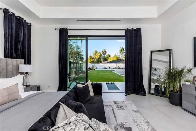 bedroom with access to exterior and a tray ceiling