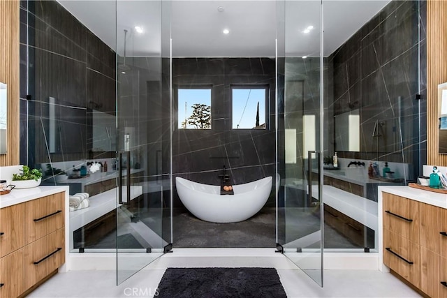 bathroom with vanity, shower with separate bathtub, and tile walls