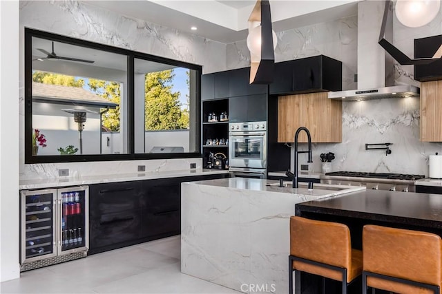 kitchen with wall chimney range hood, sink, stainless steel appliances, decorative backsplash, and beverage cooler