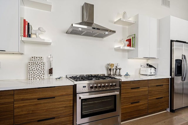 kitchen with white cabinetry, stainless steel appliances, range hood, and hardwood / wood-style floors