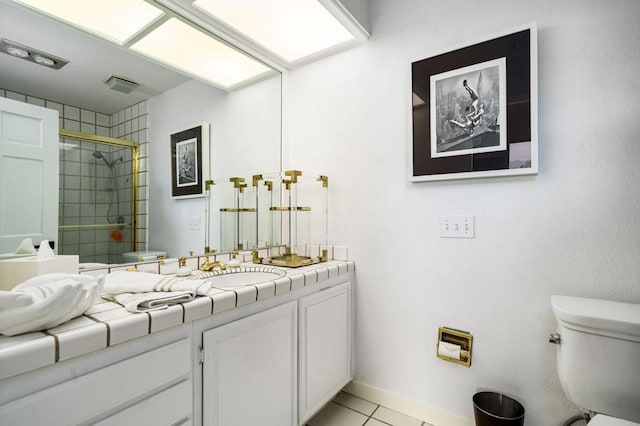 bathroom featuring tile patterned flooring, vanity, an enclosed shower, and toilet