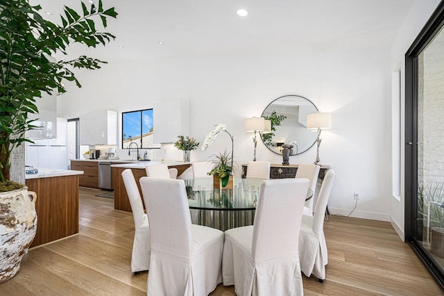 dining room with sink and light hardwood / wood-style flooring