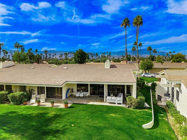 rear view of property with a patio and a lawn