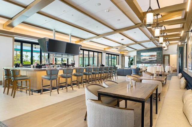 dining area featuring coffered ceiling, light hardwood / wood-style flooring, and beamed ceiling