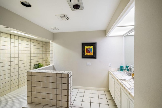 bathroom featuring vanity, tile patterned flooring, and a shower