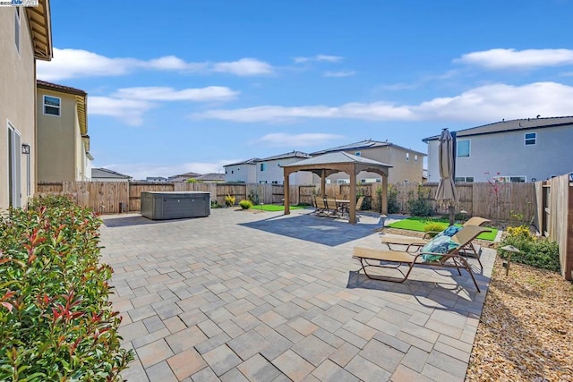 view of patio / terrace with a hot tub and a gazebo