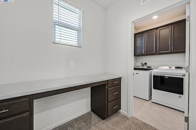 clothes washing area with cabinets, light tile patterned floors, and independent washer and dryer