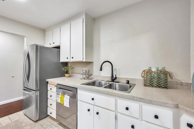 kitchen with dishwashing machine, sink, white cabinetry, and light tile patterned floors