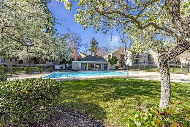 view of pool with a lawn