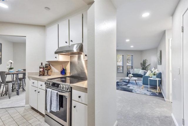 kitchen featuring white cabinetry, light carpet, and stainless steel range with electric cooktop