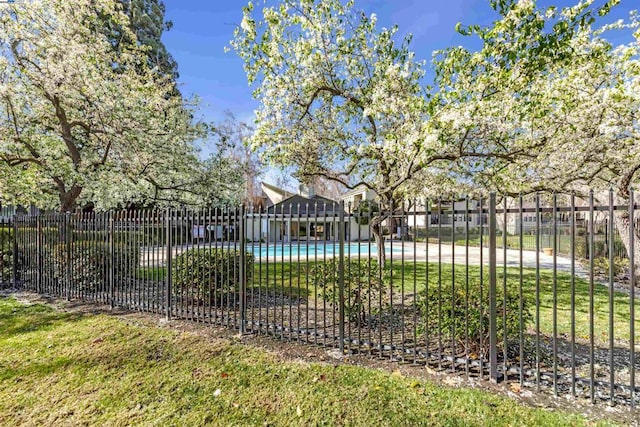 view of gate with a community pool and a yard