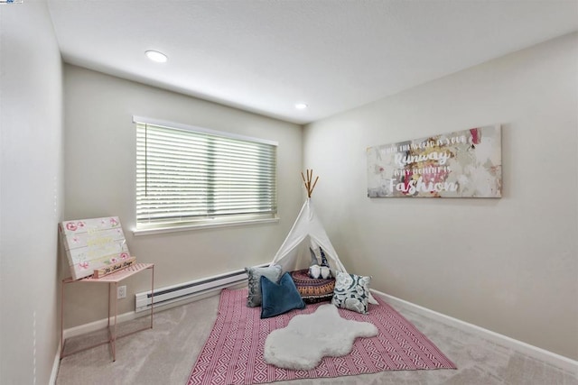 game room featuring a baseboard heating unit and light colored carpet