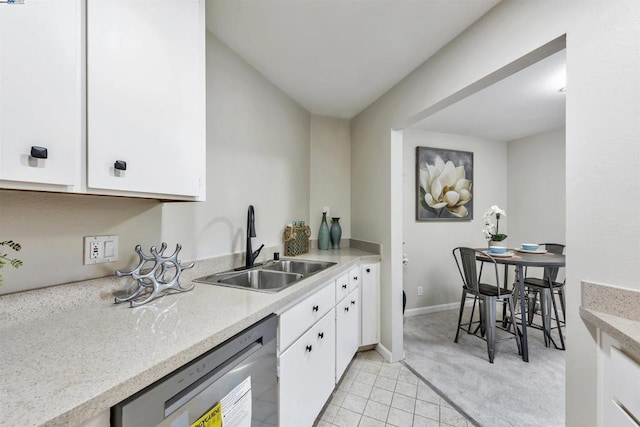 kitchen featuring dishwashing machine, sink, light tile patterned floors, and white cabinets