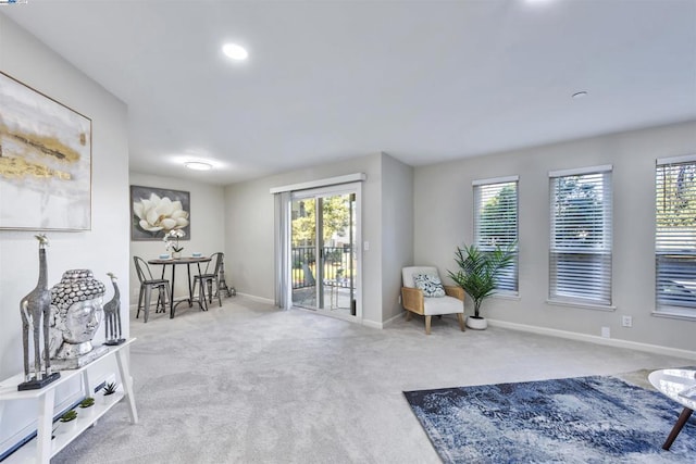 sitting room featuring plenty of natural light and light carpet