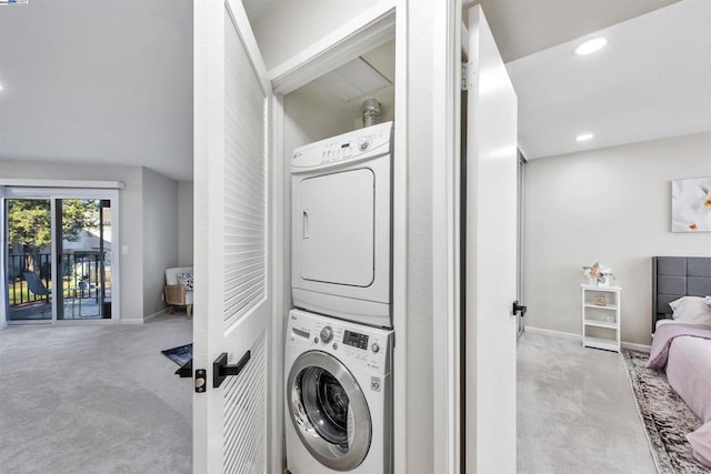 laundry room with light colored carpet and stacked washer / drying machine