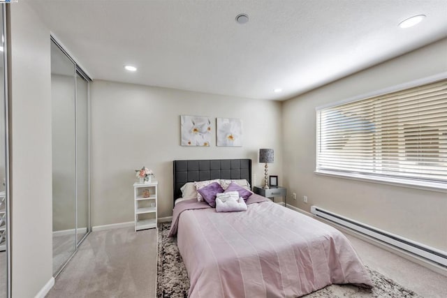 carpeted bedroom featuring a baseboard heating unit