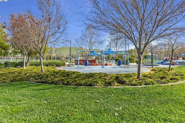 view of property's community featuring a playground and a lawn