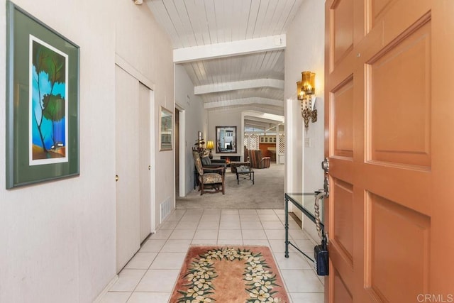 entryway featuring vaulted ceiling with beams, arched walkways, light tile patterned flooring, light colored carpet, and visible vents