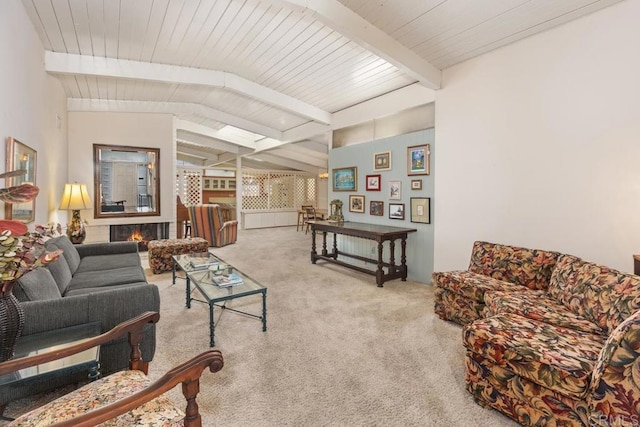 carpeted living area with vaulted ceiling with beams and a brick fireplace