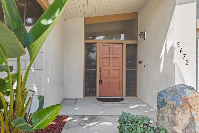 entrance to property featuring stucco siding