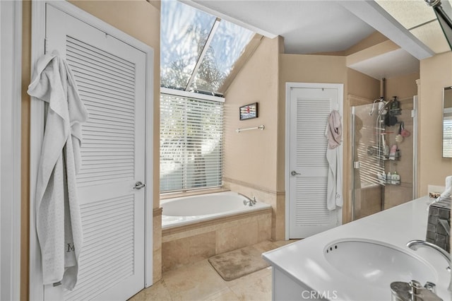 bathroom featuring tile patterned floors, vanity, and tiled bath