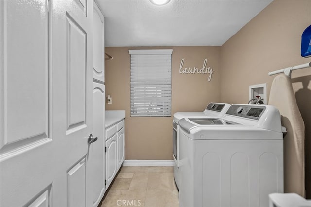 clothes washing area featuring cabinets, separate washer and dryer, and light tile patterned floors