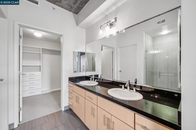 bathroom with vanity, an enclosed shower, and tile patterned flooring