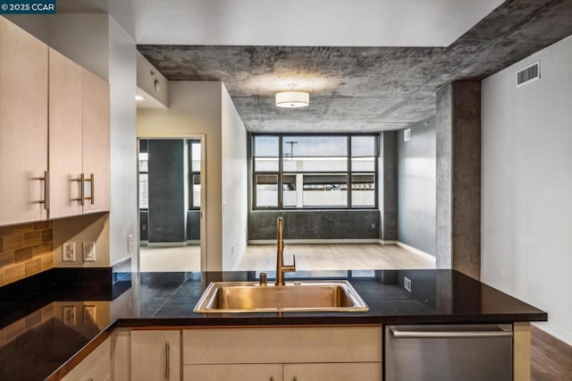 kitchen featuring hardwood / wood-style floors, dishwasher, sink, backsplash, and light brown cabinets