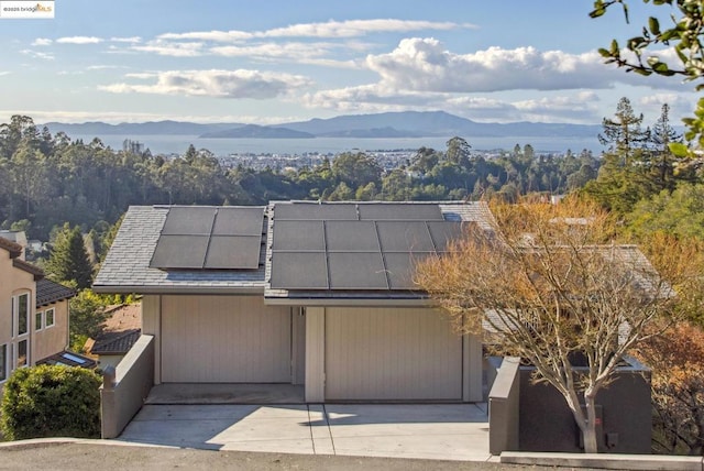 view of front of property with a mountain view and solar panels